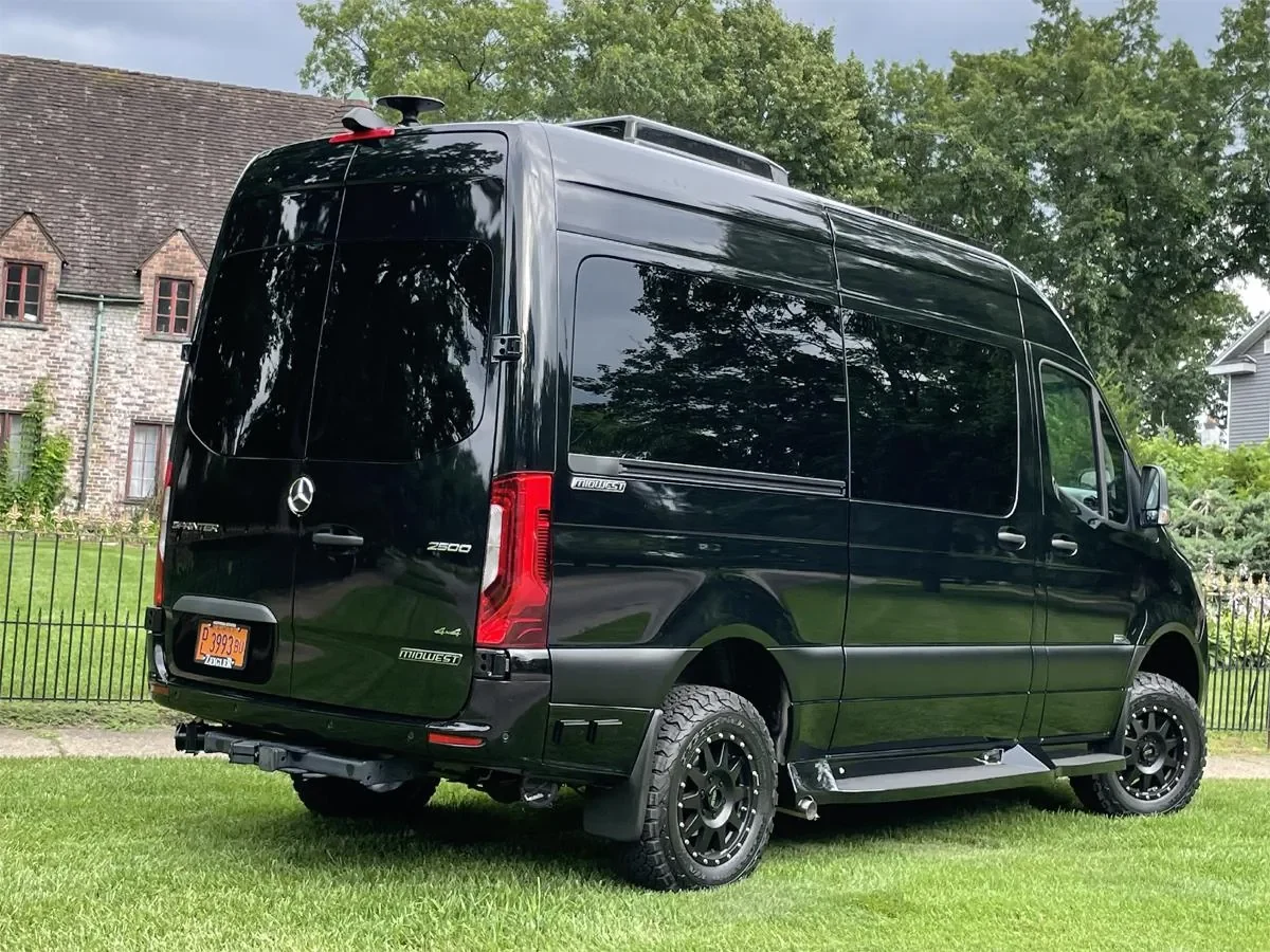 Black Mercedes Sprinter conversion parked outdoors beside a house