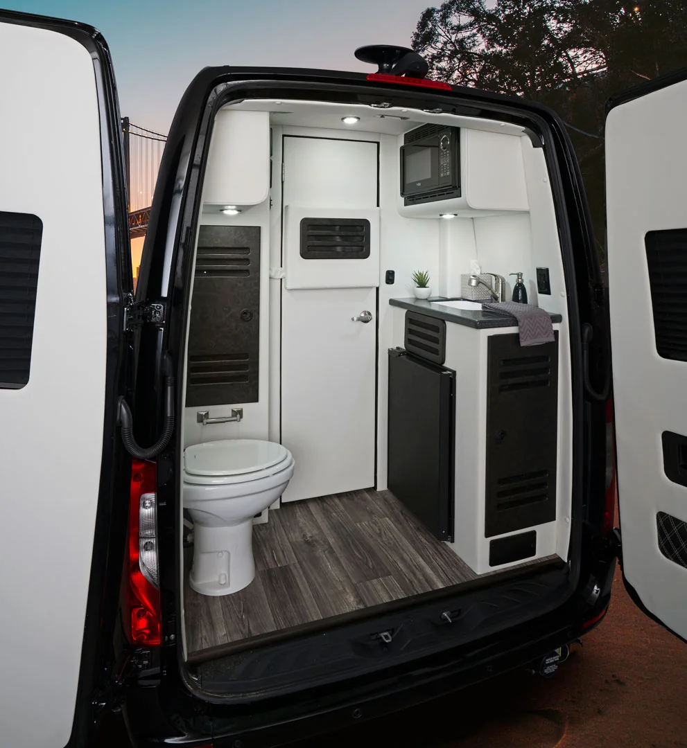 Rear Sprinter compartment with a toilet beside a compact sink and galley